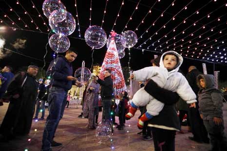 Palestinians stand in Manger Square ahead of Christmas eve in the West Bank city of Bethlehem.