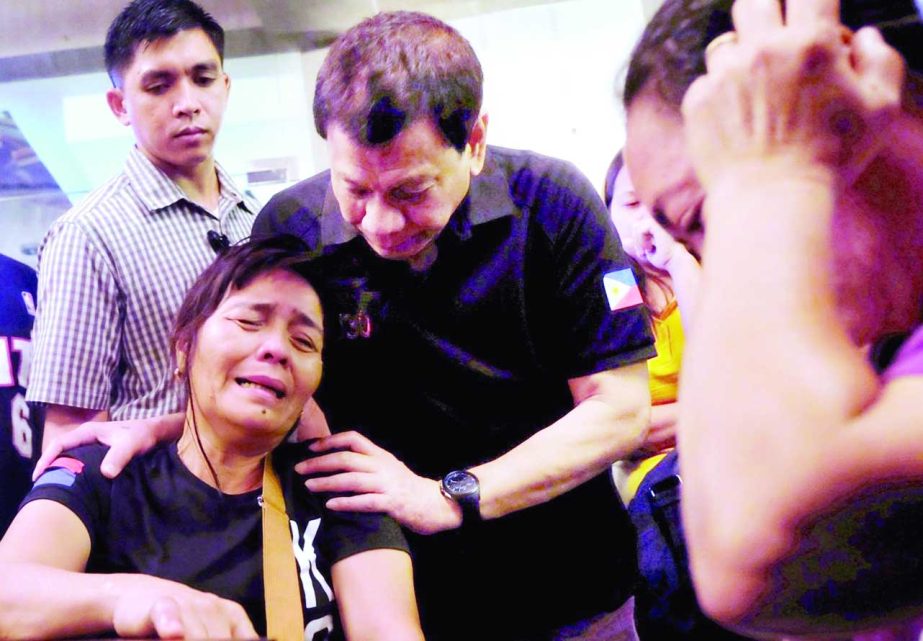 President Rodrigo Duterte comforts a family member of a fire victim in Davao city in Philippines on Sunday.