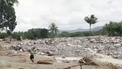 People stand in the area damaged by storm Tembin in Lanao del Norte, southern Philippines.