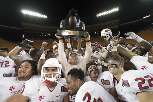 Fresno State head coach Jeff Tedford (center) holds up the Hawaii Bowl championship trophy after defeating Houston in the Hawaii Bowl NCAA college football game, on Sunday.