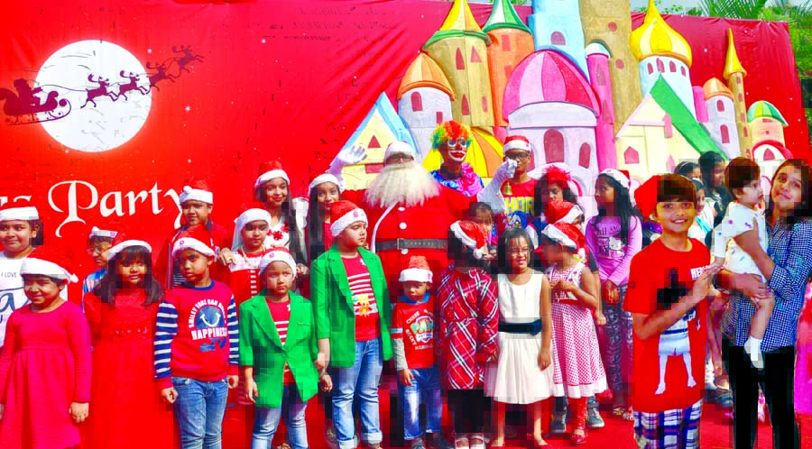 Shanta Cruz with the children of Christian community celebrating Christmas Day on Monday at Hotel Sonargaon.