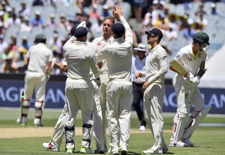 England's Stuart Broad (center) is congratulated by teammates after taking the wicket of Australia's Pat Cummins (right) during the second day of their Ashes cricket test match in Melbourne, Australia on Wednesday.