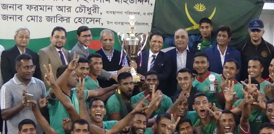 Bangladesh Army, the champions of the Shahjalal Islami Bank Limited Victory Day Volleyball Competition with the guests and officials of Bangladesh Volleyball Federation pose for a photo session at Volleyball Stadium on Wednesday.