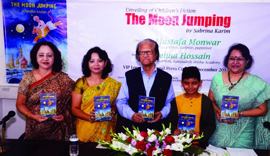 Noted Artist Mustafa Monwar along with others holds the copies of a book titled 'The Moon Jumping' by Sabrina Karim at the Jatiya Press Club on Thursday.