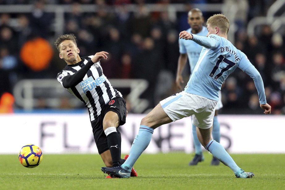 Newcastle United's Dwight Gayle (left) and Manchester City's Kevin De Bruyne battle for the ball during their English Premier League soccer match at St James' Park, Newcastle, England on Wednesday.