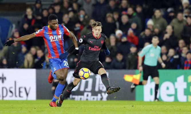 Arsenal's Mesut Ozil (right) vies for the ball with Crystal Palace's Timothy Fosu-Mensah during their English Premier League soccer match between Crystal Palace and Arsenal at Selhurst Park stadium in London on Thursday.