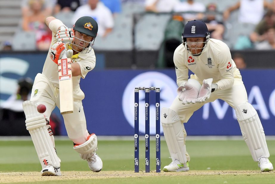 Australia's David Warner (left) drives the ball in front of England's Jonny Bairstow during the fifth day of their Ashes cricket test match in Melbourne, Australia on Saturday.