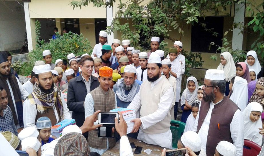 Allama Abul Farah Md Farid Uddin, Principal, Chhepatoli Aliya Madrasa distributing books among madrasa students yesterday.