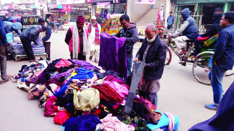 SIRAJGONJ: Peopel of low income buying winter clothes from road side hawkers at Sirajganj town yesterday.