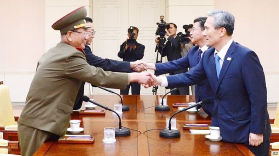 South Korean National Security Director, Kim Kwan-jin, right, and Unification Minister Hong Yong-pyo, second from right, shake hands with Hwang Pyong So, left, North Korea' top political officer for the Korean People's Army, and Kim Yang Gon, a senior N
