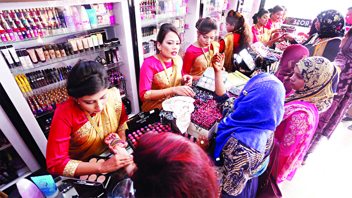 Huge visitors thronged at the Dhaka International Trade Fair on Saturday. Female visitors are seen making their choice at a cosmetics shop.
