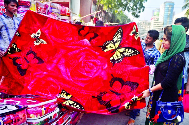 Customers crowd at the makeshift-shops to make their choice and buy winter clothes as cold wave sweeping across the country and the capital as well. This photo was taken from in front of the Baitul Mokarram on Sunday.