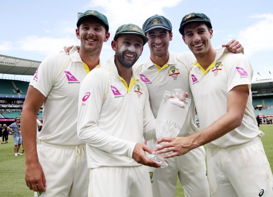 Australian bowlers Josh Hazlewood (left) Nathan Lyon, Mitchell Starc (second right) and Pat Cummins (right) hold the Ashes trophy as they celebrate at the end the last day of their Ashes cricket test match against England in Sydney on Monday. Australia wi