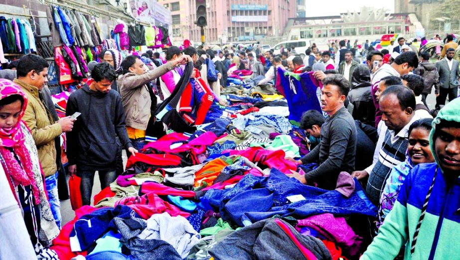 People of all walks of life crowded the makeshift shops to buy warm clothes as lowest temperature prevailing in the capital and across the country. This photo was taken from in front of Motijheel Sonali Bank head office on Monday.