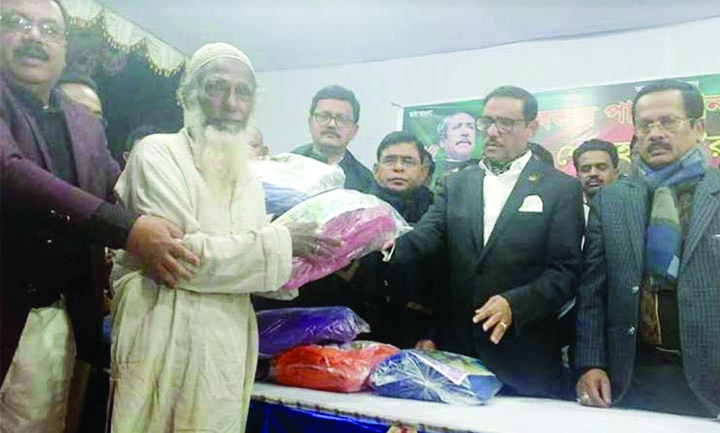 NILPHAMARI: Awami League General Secretary and Minister for Road Transport and Bridges Obaidul Kader MP distributing blankets among the cold- hit people at Five-star ground on Monday .