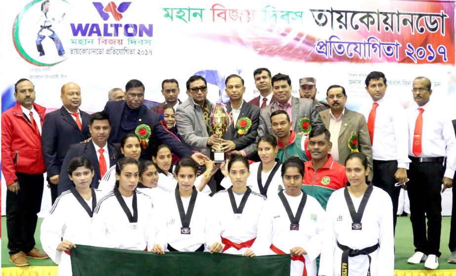 Bangladesh Army, the champions of the Men's Senior Division and the champions of the Women's Senior Division of the Walton Victory Day Taekwondo Competition with the guests and officials pose for a photo session at the Gymnasium in the National Sports C