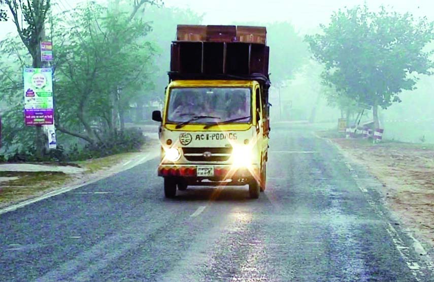 NAOGAON: Vehicle using headlight at Naogaon due to dense fog. This snap was taken on Tuesday.