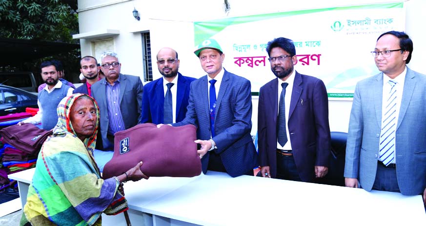 Md. Abdul Hamid Miah, Managing Director of Islami Bank Bangladesh Limited, distributing blankets among the cold affected destitute people at the bank's head office in the city on Tuesday. Abu Reza Md. Yeahia and Taher Ahmed Chowdhury, DMDs of the bank am