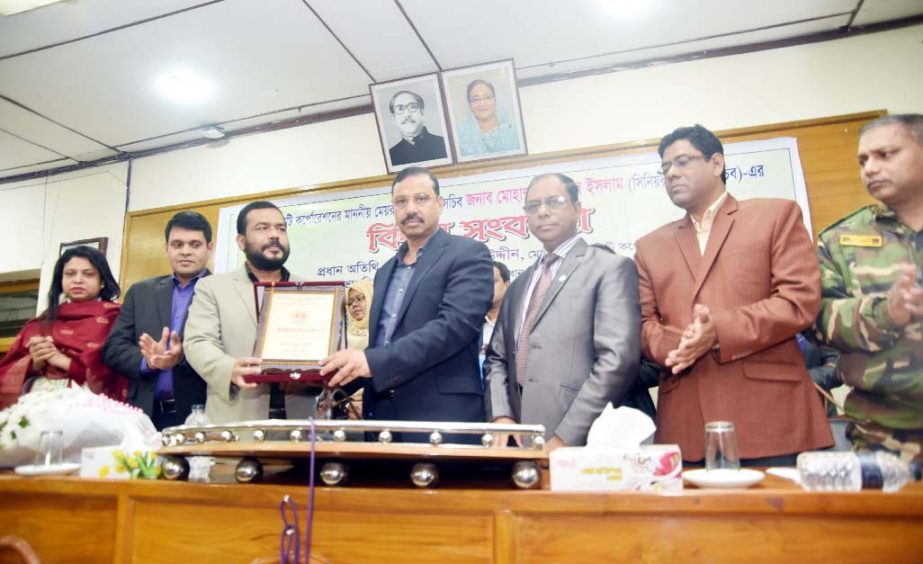 CCC Mayor A J M Nasir Uddin giving a crest to Personal Secretary to the mayor Md Monjurul lslam at the farewell reception accorded to him on Tuesday.