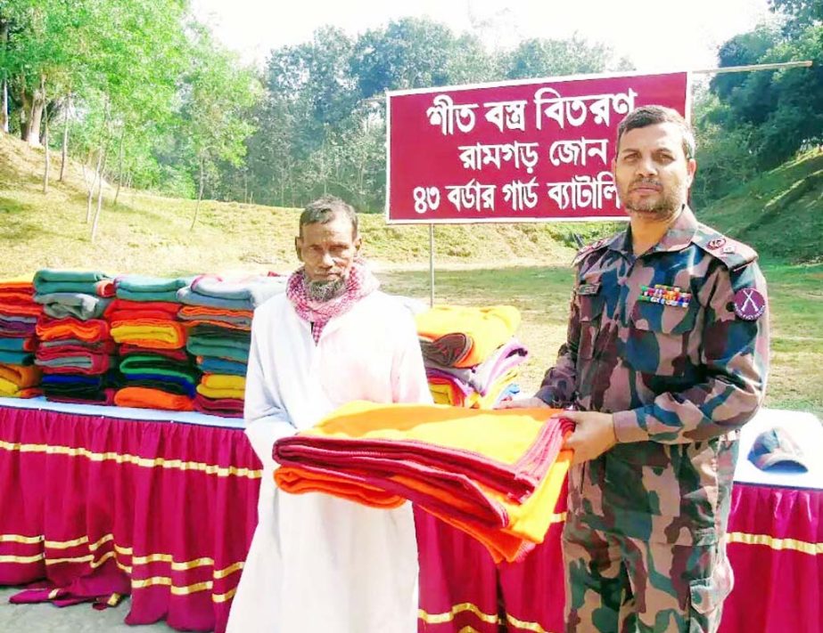 Maj Humayun Kabir of Ramgarh 43 BGB distributing warm clothes among the cold- affected people at Ramgarh yesterday.