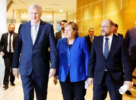 Acting German Chancellor Angela Merkel, leader of the Christian Social Union in Bavaria (CSU) Horst Seehofer and Social Democratic Party (SPD) leader Martin Schulz arrive for a press conference after exploratory talks about forming a new coalition governm