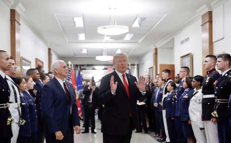 President Donald Trump stops to answer a reporter's question after greeting military personnel during a visit to the Pentagon.