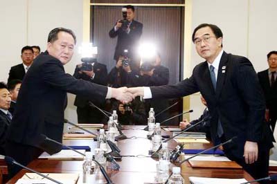 Head of the North Korean delegation, Ri Son Gwon shakes hands with South Korean counterpart Cho Myoung-gyon as they exchange documents after their meeting at the truce village of Panmunjom in the demilitarised zone separating the two Koreas.