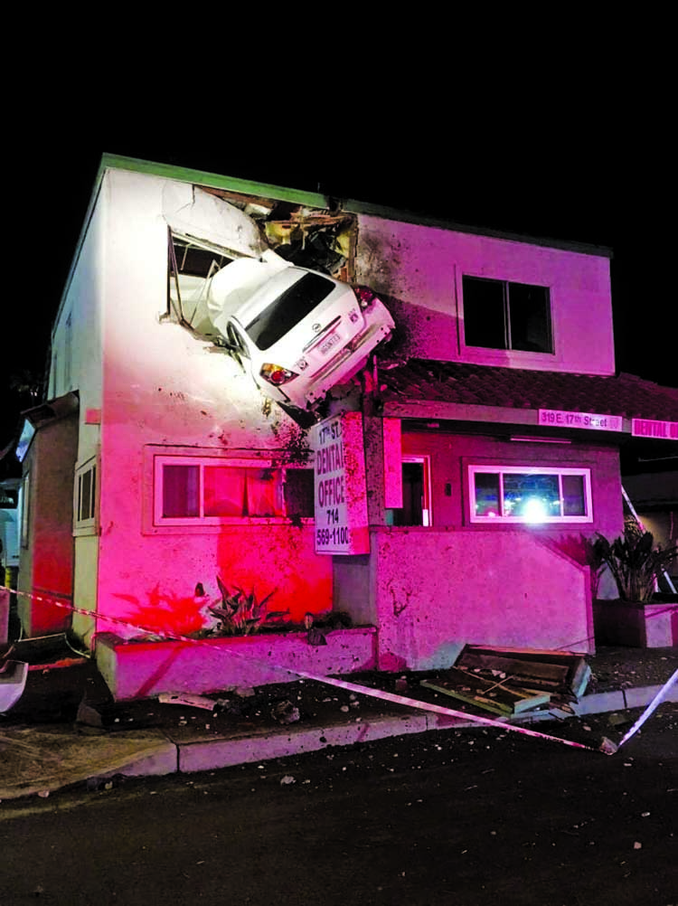 A car hit a center divider, went airborne and crashed into the second floor of a small office building in Santa Ana, Calif.