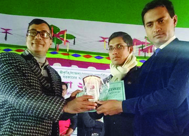 MANIKGANJ: Md Jubair, UNO, Singair Upazila giving honorary crest to Md Altaf Hossain, Chairman, Green Club at the Development Fair for contributions of the Club on environment and education organised by Upazila Administration recently.