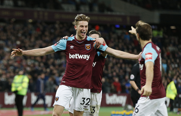 West Ham United's Reece Burke (left) celebrates after scoring the opening goal of the game in extra time during the English FA Cup third round replay between West Ham United and Shrewsbury Town at the London stadium in London on Tuesday.