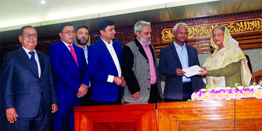 Md. Rezaul Karim, Chairman of Shippers' Council of Bangladesh (SCB) handing over a cheque of Tk 1 crore to Prime Minister Sheikh Hasina for Prime Minister's Relief and Welfare Fund at PMO on Thursday. Ariful Ahsan, Senior Vice-Chairman, Mohammad Shahjah