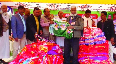 MODHUKHALI ( Faridpur): Former MP Alhaj Kazi Sirajul Islam distributing winter clothes among the distressed people at Modhukhali Central Eidgah ground on Thursday.