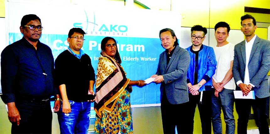 Naohide Hatakeyama Toki, Financer of 'Shako International' (a Japan based volunteer organization which is working for finances the widows and the poor worker in the RMG sector in Bangladesh) handing over a cheque to widow worker Laili Begum at a RMG fac