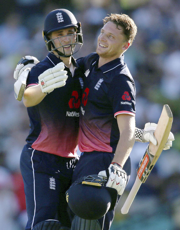 England's Jos Butler, right, celebrates with batting partner Chris Woakes after Butler made 100 runs against Australia during their one day international cricket match in Sydney on Sunday.