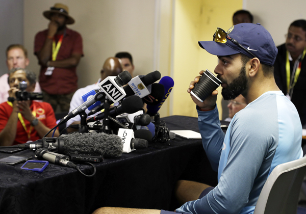 India's captain Virat Kohli takes a drink whilst taking a question from a journalist during a media conference at the Wanderers Stadium in Johannesburg, South Africa on Tuesday, ahead of their 3rd and final cricket Test match against South Africa.