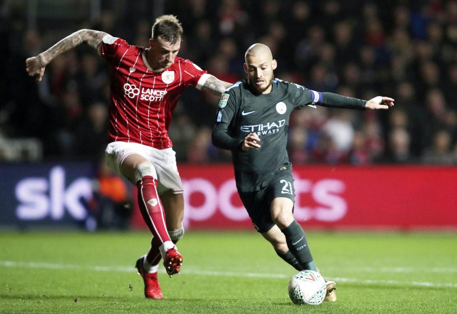 Bristol City's Aden Flint (left) and Manchester City's David Silva battle for the ball during the English League Cup semi final, second leg match at Ashton Gate in Bristol, England on Tuesday.