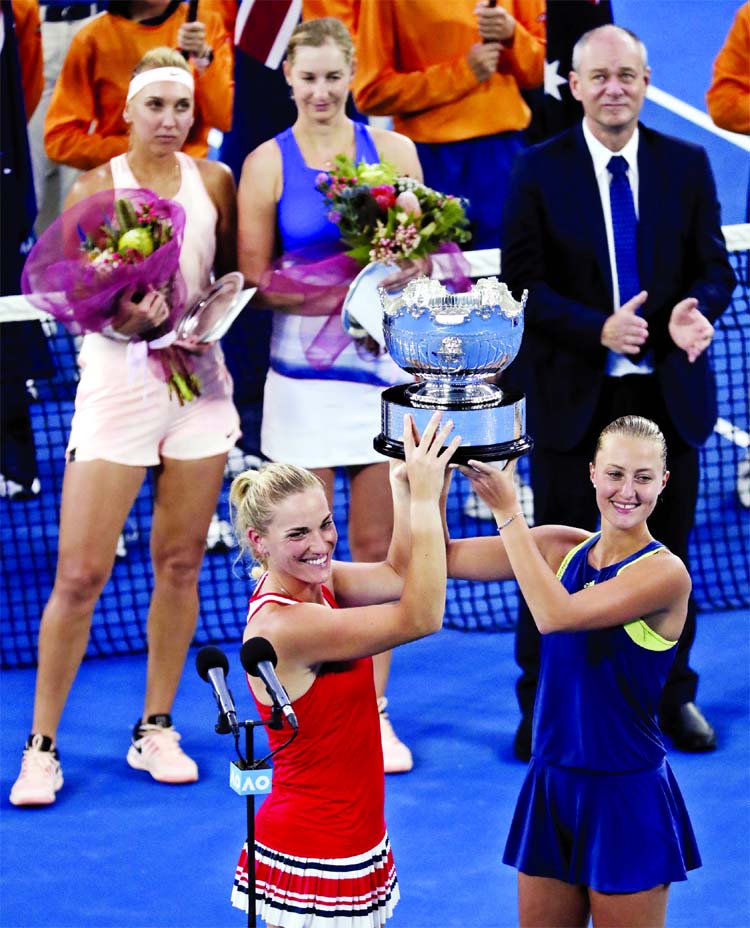 Hungary's Timea Babos n(front left) and partner France's Kristina Mladenovic hold their trophy aloft after they defeated Russia's Ekaterina Makarova and Elena Vesnina in the women's doubles final at the Australian Open tennis championships in Melbourn