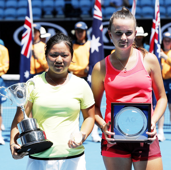 Taiwan's Liang En Shuo (left) holds her winners trophy after defeating France's Clara Burel, right, in the girl's singles final at the Australian Open tennis championships in Melbourne, Australia on Saturday.