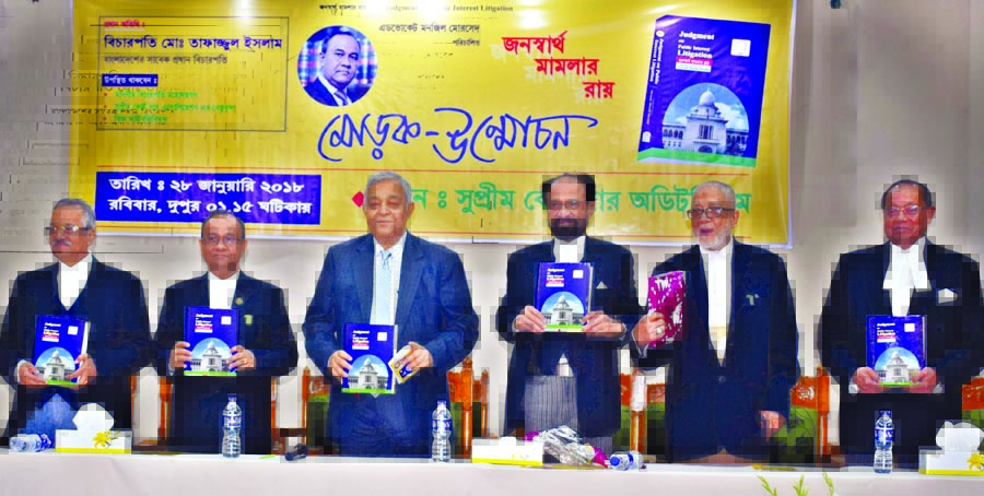 Former Justice Tafazzal Islam along with other distinguished persons holds the copies of a book titled 'Janaswartha Mamlar Roy' written by Adv. Manjil Morshed at its cover unwrapping ceremony in the Supreme Court Bar Auditorium on Sunday.