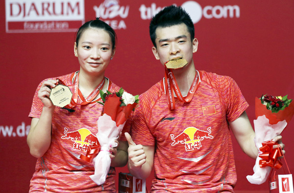 China's Zheng Siwei (right) and Huang Yaqion pose with their gold medals after beating Indonesia's Tontowi Ahmad and Liliyana Natsir in their mixed doubles final match the Indonesia Masters badminton tournament at Istora Stadium in Jakarta, Indonesia on