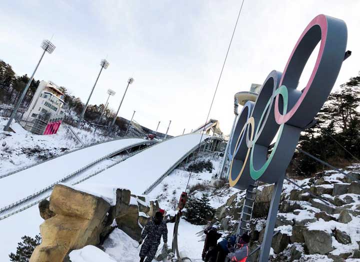 Workers install Olympic Rings at the Alpensia Ski Jumping Centre in Pyeongchang, South Korea.