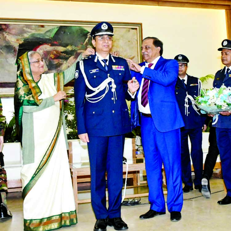 Prime Minister Sheikh Hasina wearing rank badge to the newly-appointed IGP Dr Mohammad Javed Patwari at Gono Bhaban in the city yesterday. Photo : BSS