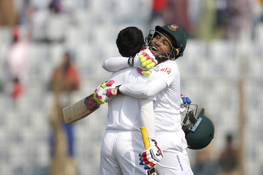 Mushfiqur Rahim (right) embrace his teammate Mominul Haque after scoring hundred runs during the first day of their first test cricket match against Sri Lanka in Chittagong on Wednesday.