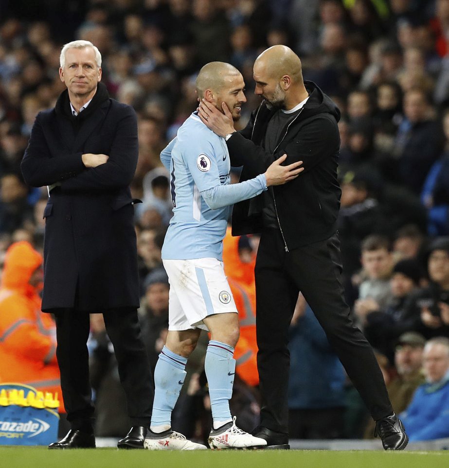 West Bromwich Albion manager Alan Pardew watches as Manchester City's David Silva leaves the pitch with an injury and is consoled by manager Pep Guardiola during the English Premier League soccer match Manchester City versus West Bromwich Albion at the E