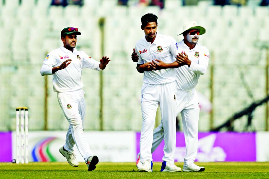 Bangladesh's Mustafizur Rahman (center) celebrates with his teammates Imrul Kayes (right) and Mehidy Hasan Miraz the dismissal of Sri Lanka's Dhananjaya de Silva during the third day of their first Test cricket match in Chittagong on Friday.