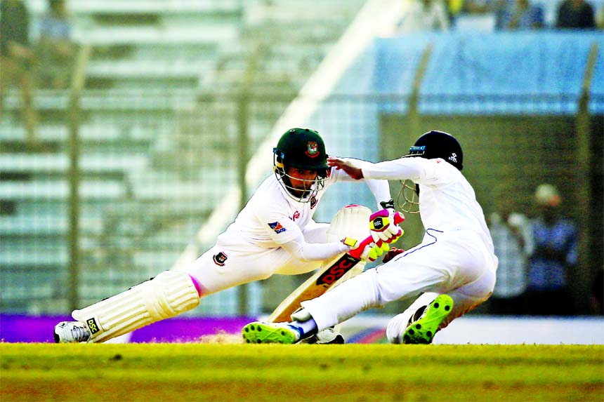 Sri Lanka's Kusal Mendis (right) drives to catch the ball successfully dismiss of Bangladesh's Mushfiqur Rahim (left) during the fourth day of their first Test cricket match in Chittagong on Saturday.