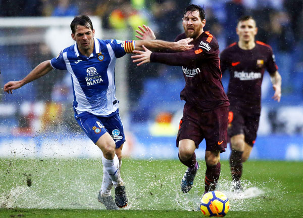 FC Barcelona's Lionel Messi (right) duels for the ball against Espanyol's Victor Sanchez during the Spanish La Liga soccer match between Espanyol and FC Barcelona at RCDE stadium in Cornella Llobregat, Spain on Sunday.
