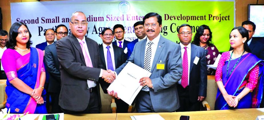 Md. Mehmood Husain, Managing Director of NRB Bank Limited and Md. Abul Bashar, General Manager of Financial Inclusion Department of Bangladesh Bank (BB), exchanging a participatory financial institutions agreement signing documents on refinance under 'Se