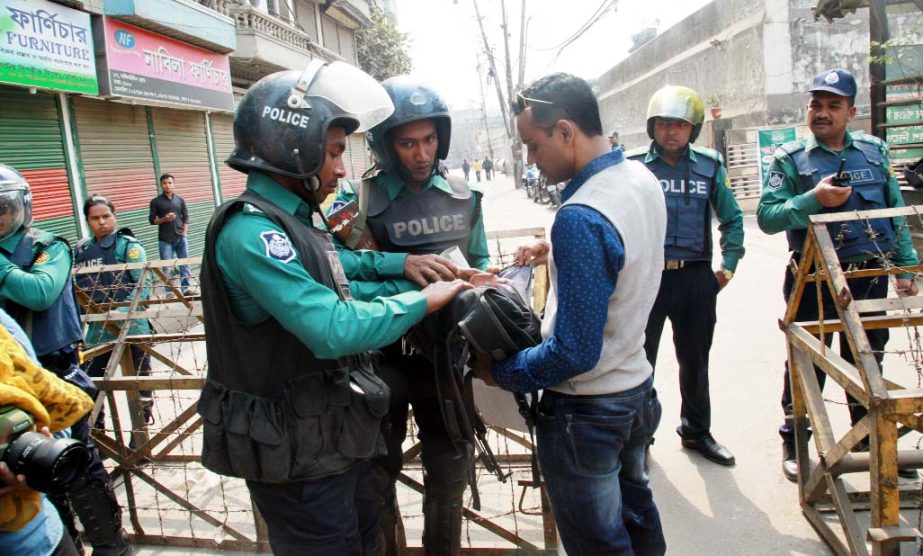 Law-enforcers checking the bags of pedestrians for security reasons. The snap was taken from the city's Nazimuddin Road on Friday.