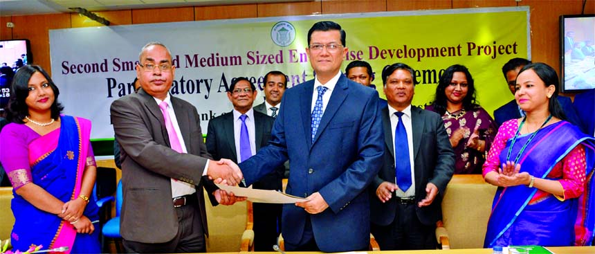 Md. Ahsan-uz Zaman, Managing Director of Midland Bank Limited and Md. Abul Bashar, General Manager of Financial Inclusion Department of Bangladesh Bank (BB), exchanging a participatory financial institutions agreement signing documents on refinance under